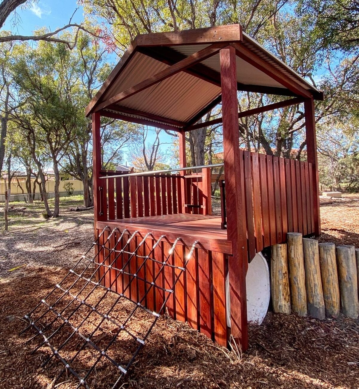 Maximize the use of your sloped site with our innovative Takari Cubby platform, featuring ground-level access and challenging rope climbs leading to a shaded elevated deck crafted from West Australian Jarrah.