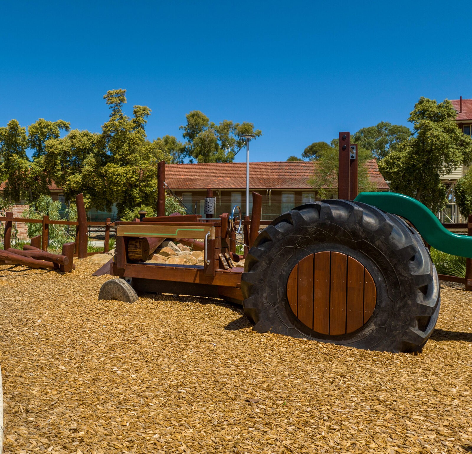 Tractor | Cultivate playground fun with this West Australian Jarrah Tractor, featuring salvaged tyres, stainless steel detailing, bench seat platform with slide, and open engine bay for imaginative farm play. | VRI