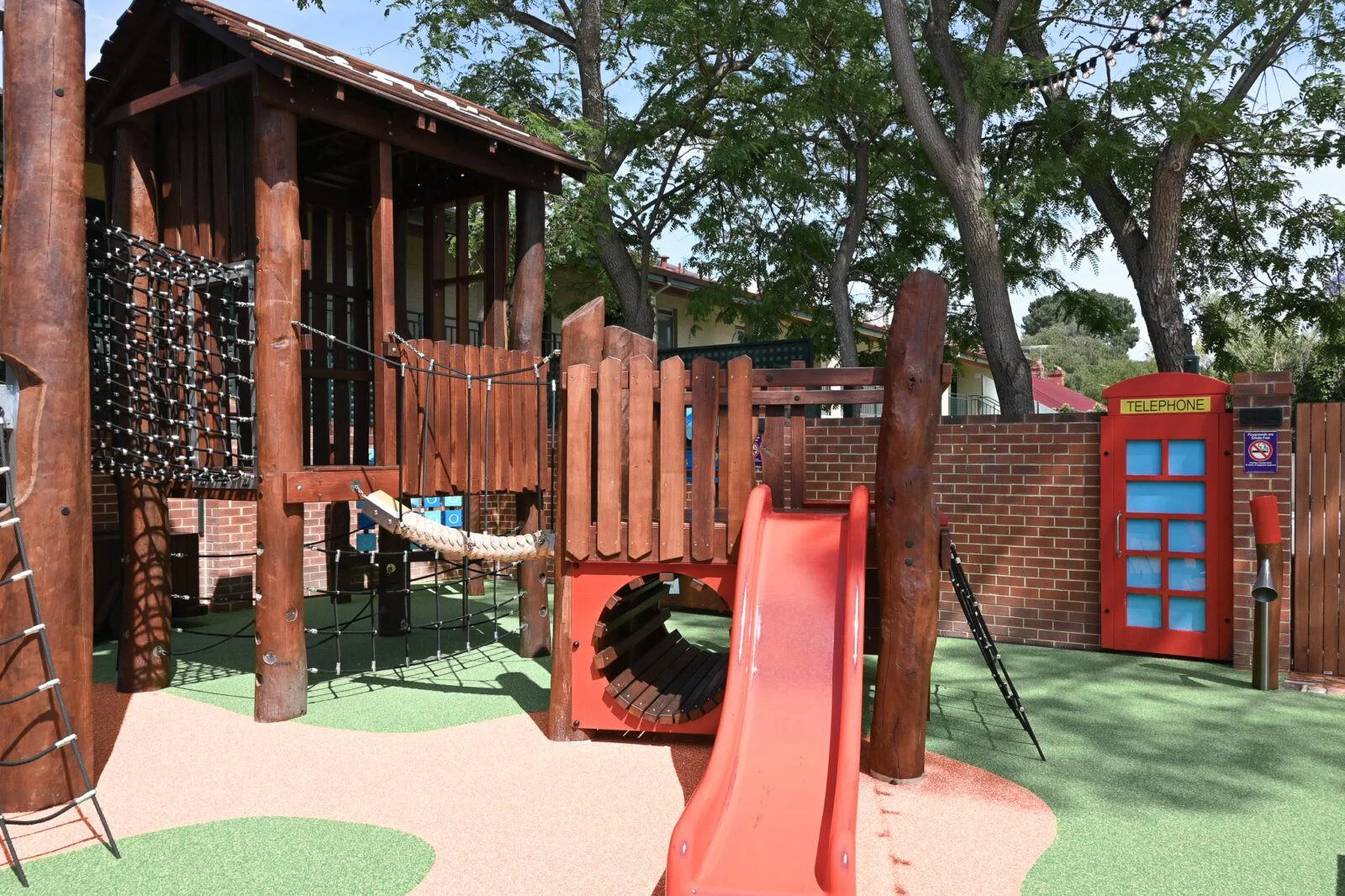 Commercial playground equipment at The Bayswater Hotel — timber play structure, rope ladder, and red slide, Bayswater WA