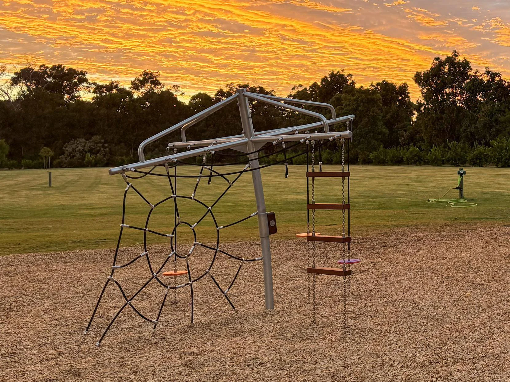 432-CLC Clothesline Climber — full structure sunset view showing elevated clothesline cable traverse and spider web net, commercial playground equipment