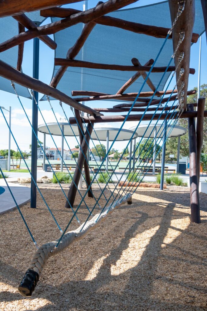Van Ryt Industries 241-VWN Viking Swing with Nest Top — symmetrical perspective along the rope traverse showing blue tensioning ropes and central braided rope, Wilson Park
