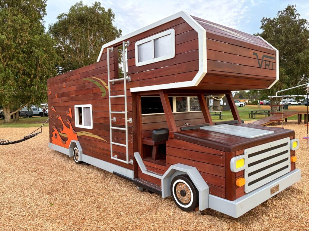 524-MTH Motorhome — three-quarter front view showing Winnebago-style flame decals, roof ladder access and open cab entry