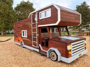 524-MTH Motorhome — three-quarter front view showing Winnebago-style flame decals, roof ladder access and open cab entry
