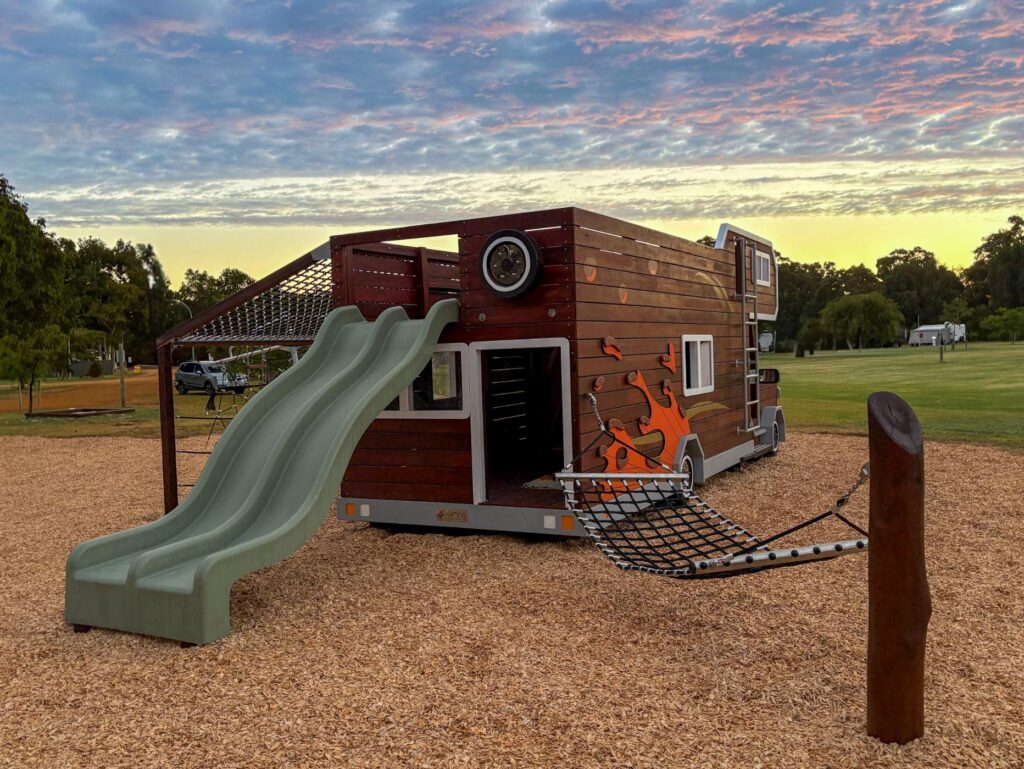 524-MTH Motorhome — rear three-quarter at dusk showing 1.8m double slide exit, rope net awning platform and hammock post