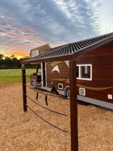 524-MTH Motorhome — rear three-quarter at dusk showing 1.8m double slide exit, rope net awning platform and hammock post