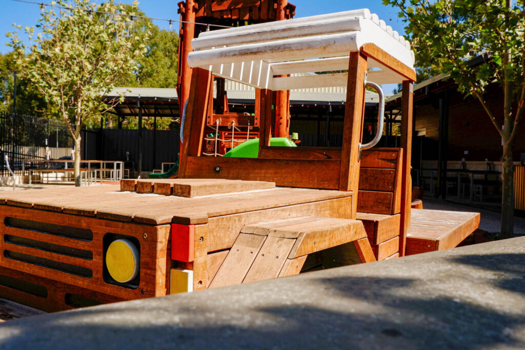 Timber Ute front cab with white canopy and green slide from tray at Charlie's Paddock playground
