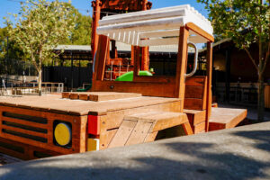 Timber Ute front cab with white canopy and green slide from tray at Charlie's Paddock playground