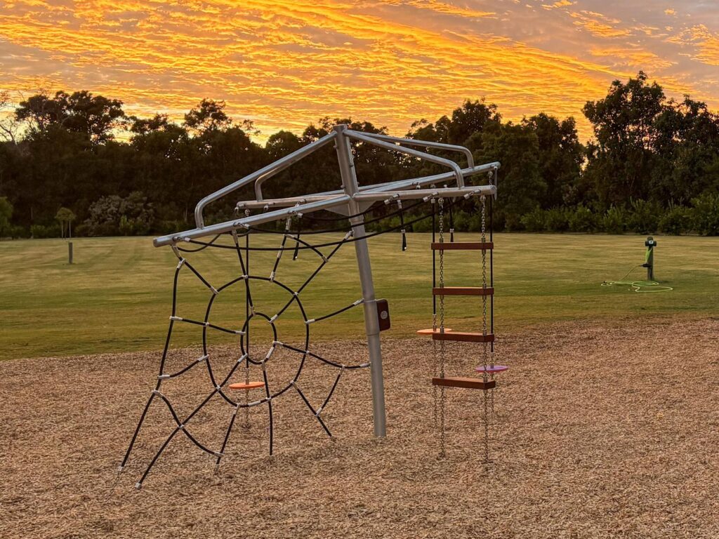 432-CLC Clothesline Climber at golden hour — spider web net and Jarrah rope ladder, commercial climbing frame playground BIG4 Dunsborough WA
