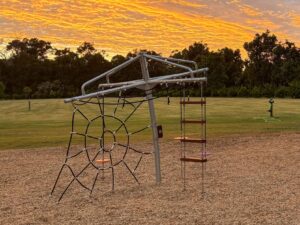 432-CLC Clothesline Climber at golden hour — spider web net and Jarrah rope ladder, commercial climbing frame playground BIG4 Dunsborough WA