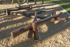 Crossed Jarrah timber logs forming log scramble climbing element on bark mulch at Hathaway Reserve playground Baldivis