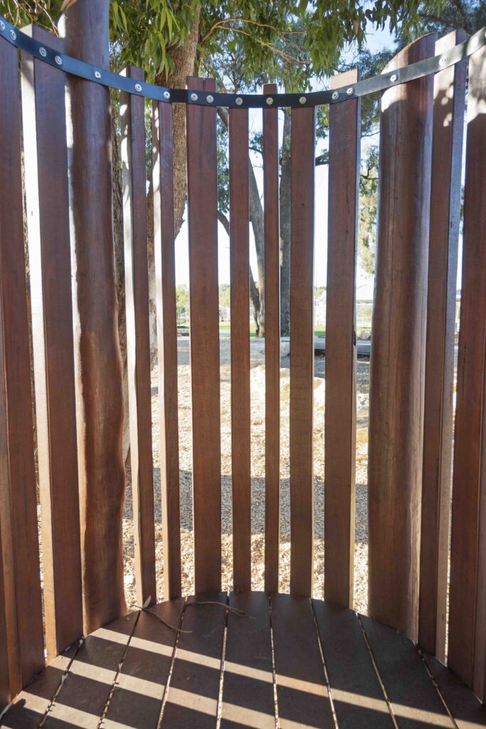 Interior view of circular Jarrah bushpole pod showing timber deck platform and uniform pole arrangement at Hathaway Reserve Baldivis