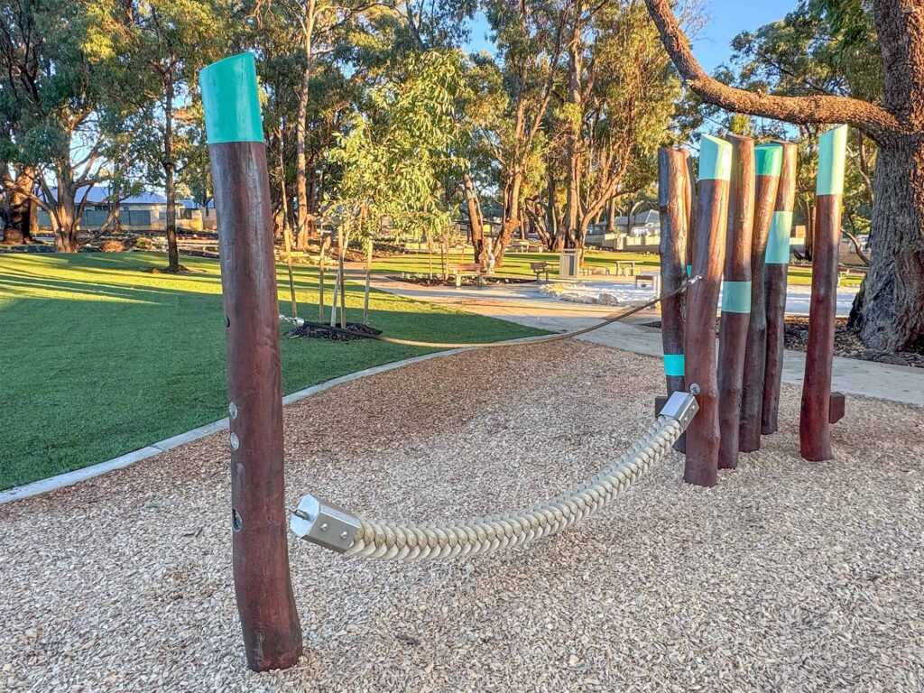 Rope traverse play element strung between Jarrah timber bushpoles at Hathaway Reserve playground Baldivis