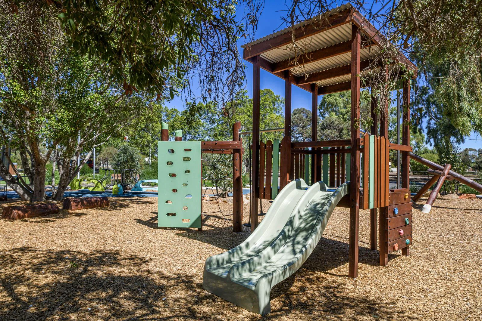 Jarrah climbing frame WA — Merredin Combo A aerial view showing elevated cubby, rope net, and corrugated roof in native landscaped park